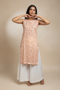 High-quality studio portrait of Indian model in peach kurti with white palazzo