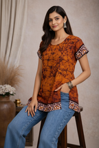 Seated pose in orange tie-dye tunic top